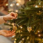 women decorates a pre lit Christmas tree