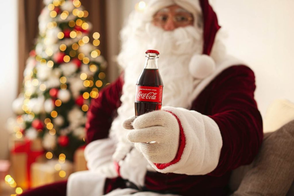 Santa Claus holds a bottle of Coca Cola