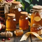 A beautifully arranged tabletop display featuring diverse honey jars with Hebrew labels, wooden dippers, apples, pomegranates, and festive ribbons, symbolizing traditional Rosh Hashanah gifts.