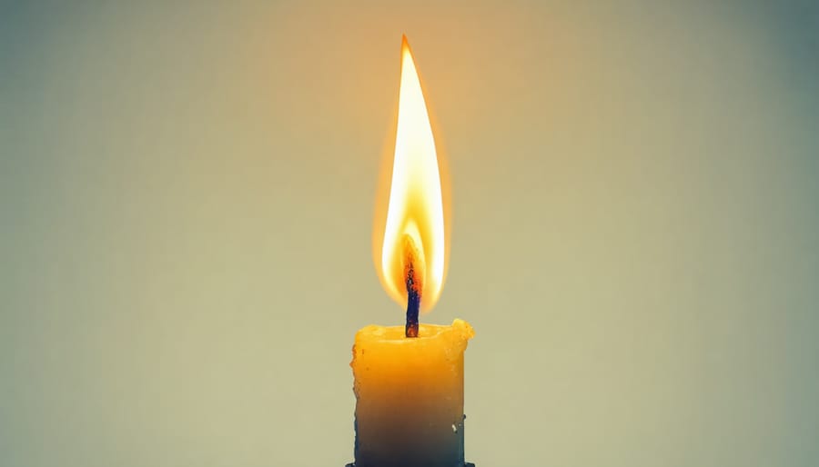 Single candle flame with scattered light reflections in darkness