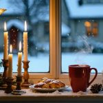 Eye-level photo of a Swedish Christmas window featuring an illuminated paper advent star and four-candle holder beside a straw Yule goat, saffron buns, and steaming glögg, with snowy trees softly blurred outside.